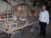 Ein Marktwagen beladen mit Eierkörben, Transportkisten für Geflügel, Milchkanne und Reisigbesen