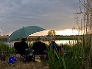 Drei Angler sitzen am Ufer der Wörnitz bei Oettingen und angeln